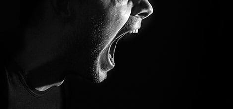Shouting man against black background